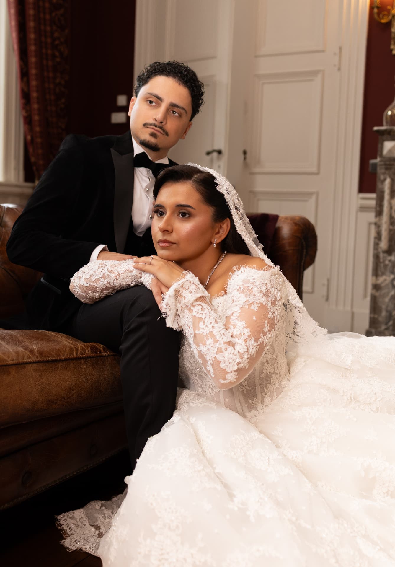 An elegant seated wedding portrait with a flowing lace gown