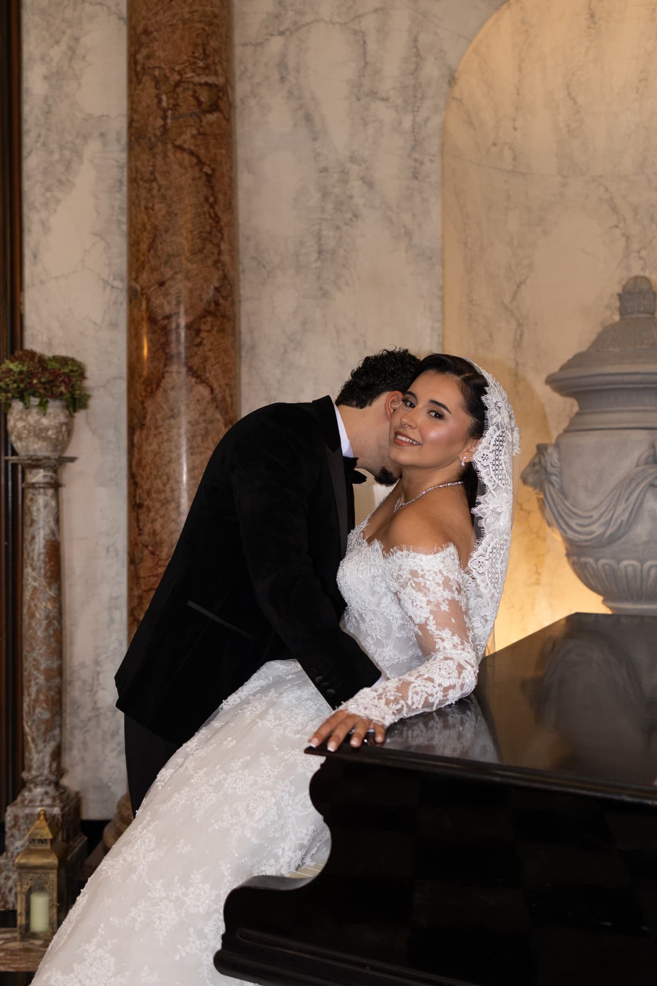A couple sharing a tender moment beside a grand piano